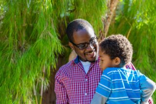 photo - African American father holding young son