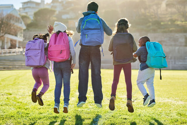 photo - Backs of Elementary Students in a Row Jumping