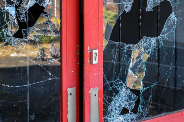 photo - Broken Windowpane and Red Doors