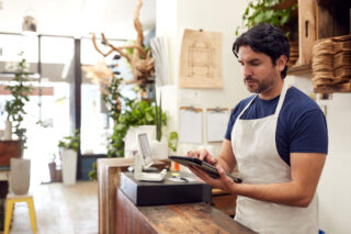 photo - Business Owner Using Digital Tablet In Store