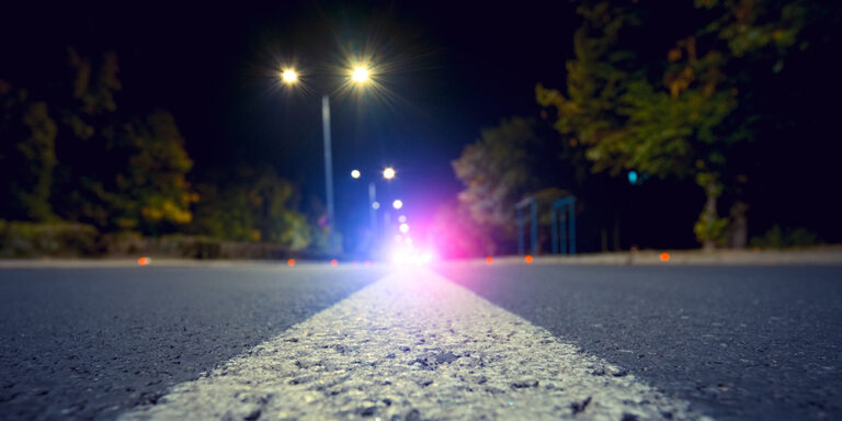 photo - City Road with Blurred Police Car Red and Blue Lights