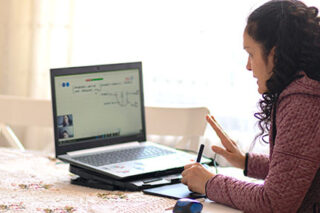 photo - College Student Online Learning at Kitchen Table