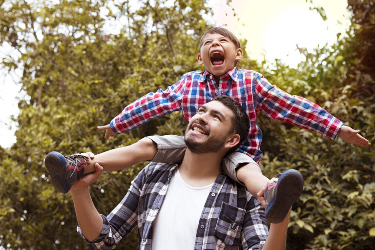 photo - Dad Carrying Son on His Shoulders in Park