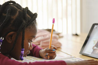 photo - An Elementary School Student Working at Home, Using a Tablet