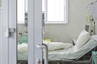 photo - Empty ICU Bed Behind Glass Door