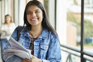 photo - Female College Student Holding Notebook in Unversity Corridor