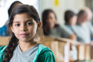 photo - Girl in Front of Line of Adults Packing Boxes with Food