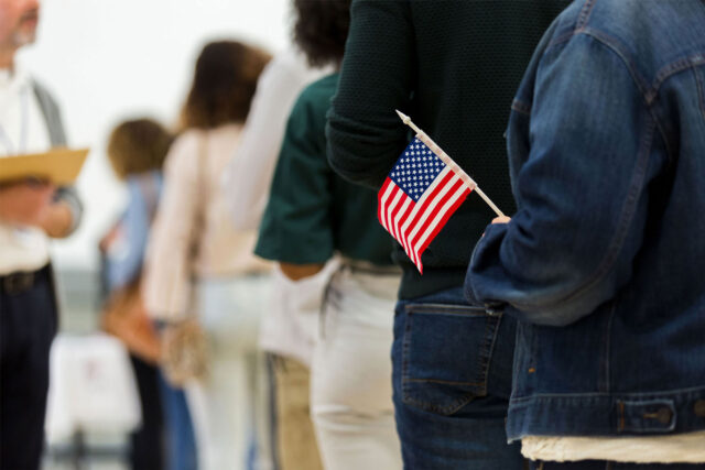 photo - Handheld US Flag and People Standing in Line