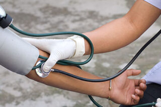 photo - Health Professional Checking Blood Pressure