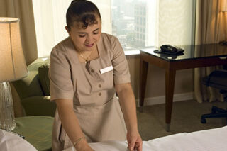 photo - Maid Making Bed In Hotel
