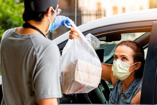 photo - Masked Woman in Car Picking Up Meals