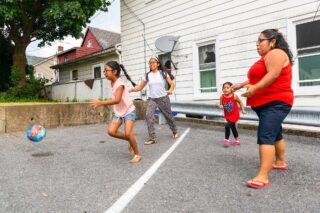 photo - Mother and Children Playing Ball Outdoors