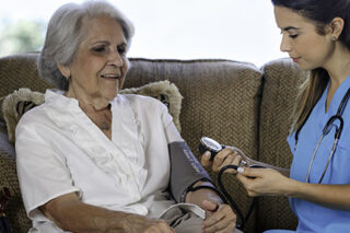 photo - Nursing Home AssistanceTaking Blood Pressure of Senior Woman