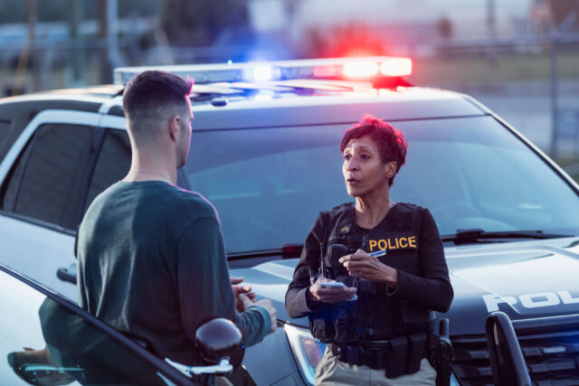 photo - Policewoman Taking a Statement from a Young Man