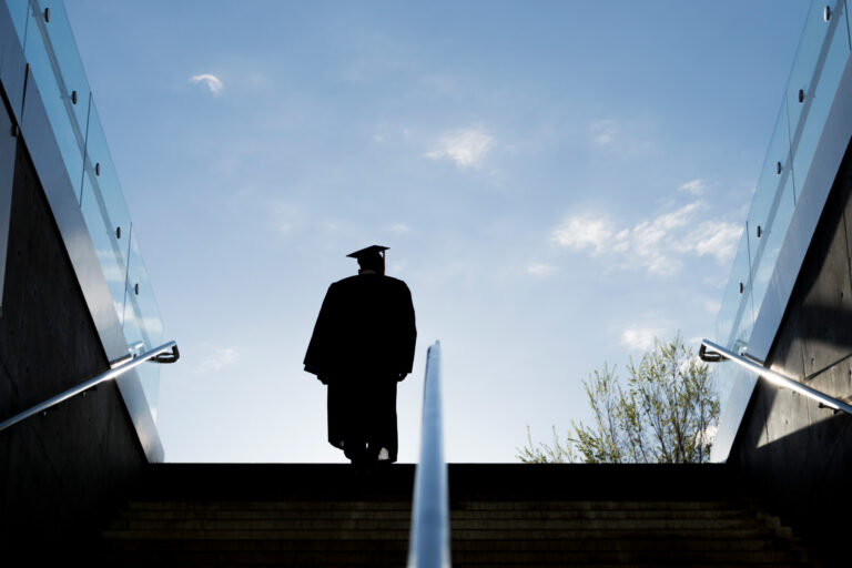 photo - Silhouette of College Graduate Climbing Steps