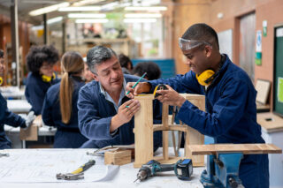 photo - Student Building Furniture with Help From Teacher