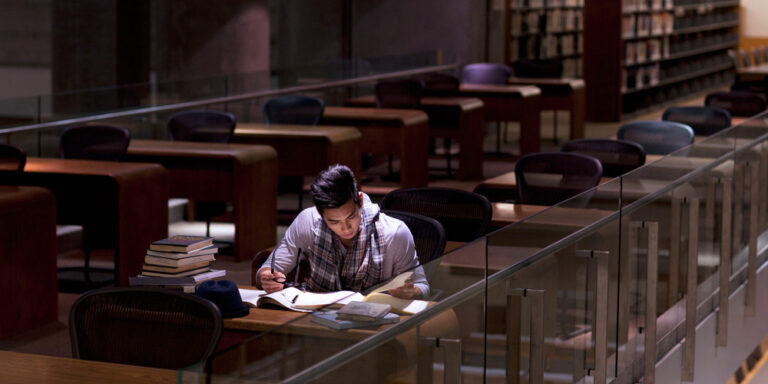 photo - Student Working in Library at Night