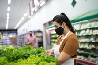 photo - Supermarket Worker Arranging Vegetables and Wearing Mask