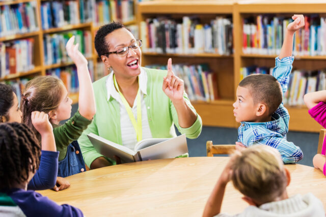 photo - Teacher Reading to Students in School Library