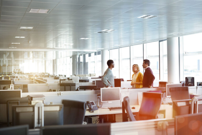 photo - Three Work Colleagues Talking in Open Office