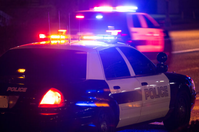 photo - Two Police Cars at Night with Lights On