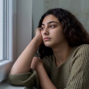 photo - Unhappy Young Woman Looking Out Window