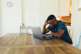 photo - Worried Man on Laptop at Home