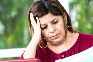 photo - Worried Woman Looking at Bills